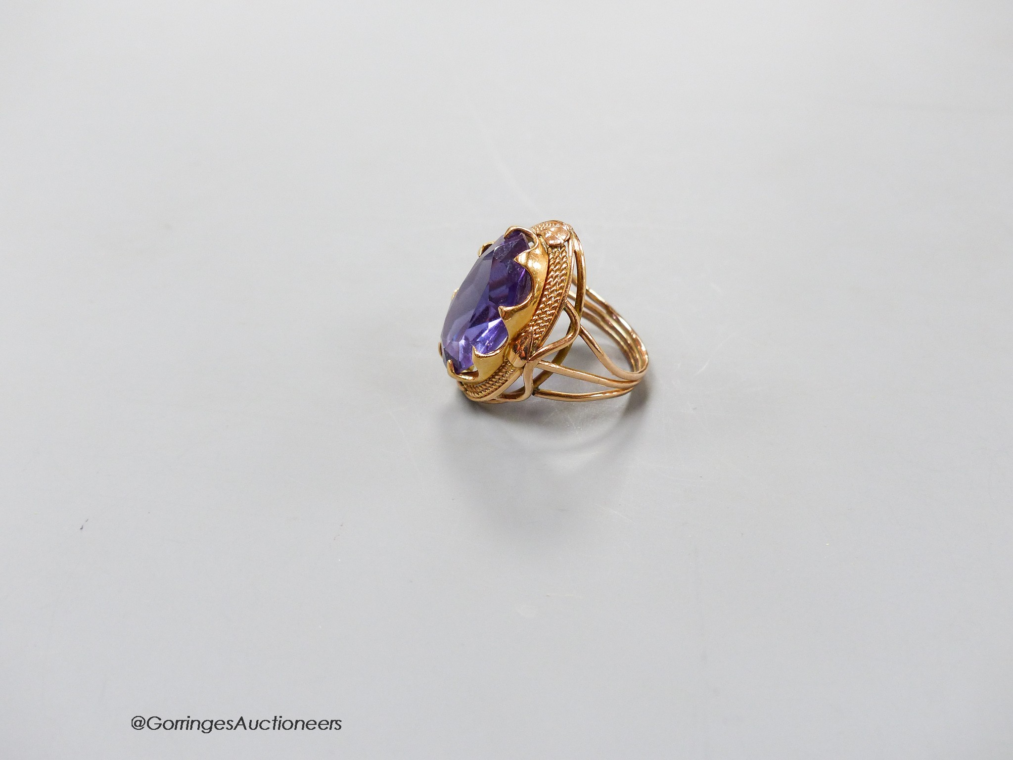 A yellow metal and synthetic colour change sapphire set oval dress ring, size O, gross 8.7 grams.